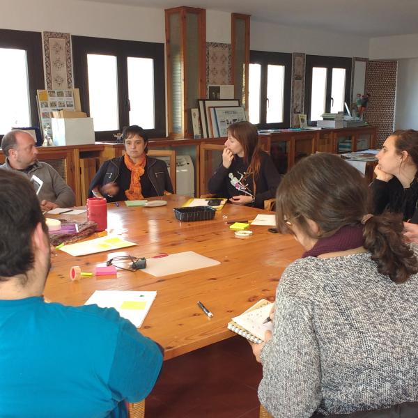 Imatge persones assegudes al voltant d'una taula fent formació