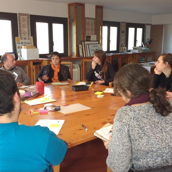 Formació equip Imatge persones assegudes al voltant d'una taula fent formació